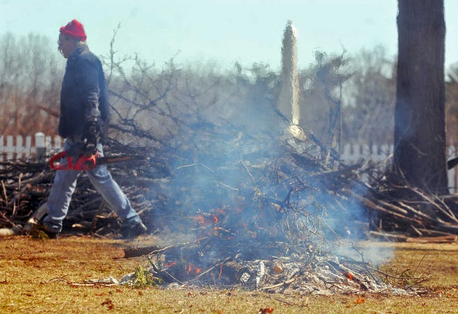 Carl W. Johnson of Church Street in West Boylston cuts storm branches for burning.
