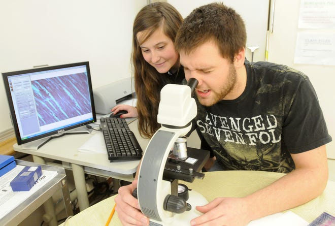 Stockton High School juniors Emilee Wolfe and Mitch Dagle use a digital microscope at the school Monday.