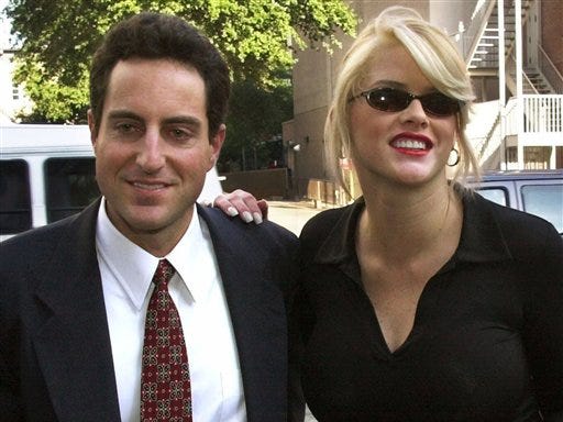 In this Oct. 2, 2000 file photo, Anna Nicole Smith, right, smiles as she walks to the courthouse with her attorney Howard K. Stern in Houston. Stern and two doctors were charged Thursday, March 12, 2009 with conspiracy to furnish drugs to the former Playboy playmate before she died of an overdose in 2007.