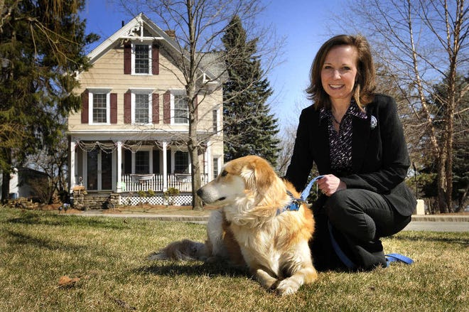 Elizabeth A. Proko, a member of Worcester Citizens for Business, and the family dog, Apollo, sit across the street from their home on Holden Street yesterday morning. Worcester Citizens for Business wants the city to gradually go to a single tax rate for residents and businesses.