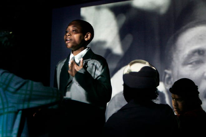 A student portrays Martin Luther King Jr. in a short play by the Duval Drama Theater to show how the Super Classroom can be used as a black box theatre with highly interactive multi-media capabilities.