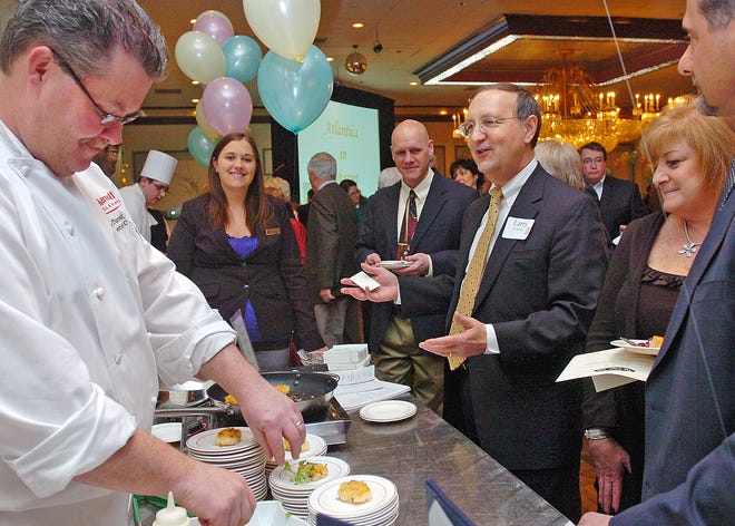 Larry DiNardo, third from right, of Hanover, is ready to try a sample of shrimp and maple pepper bacon risotto cakes prepared by Brad Turnbull, left, chef at the Quincy Marriott. during the South Shore YMCA's A Taste of the South Shore at Lombardo's in Randolph. Twenty-three local restaurants took part in the annual fund-raiser, and proceeds from the event will benefit the YMCA's Strong Kids Campaign, which provides more than $1 million in direct financial assistance and youth programming to thousands of families each year.