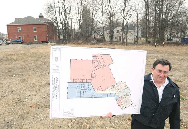 Westboro Fire Capt. Joe R. Lawrence holds a schematic of the new public safety complex for the town. The building would replace the old fire station, pictured at rear, with a multiuse structure that includes a new fire station.