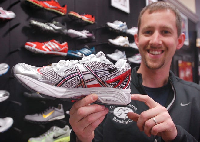 Sam Pitts, manager Greater Boston Running Co. in Hingham, displays a running shoe.