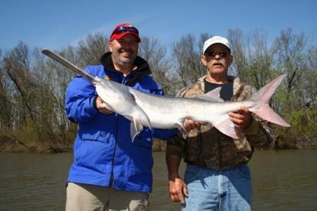 Kent Dodds (left) poseD with his first-ever paddlefish, a 30-pounder, he caught with the help of guide Steve Shirley.