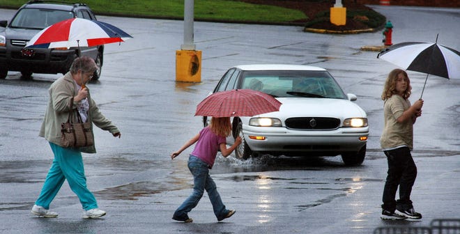 Shoppers try to stay dry under their umbrellas as they head to the grocery store in Spartanburg on Saturday morning. The drenching the area received this past week has narrowed this year’s rainfall deficit, and more precipitation could be on the way.