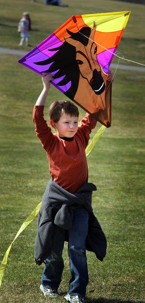 Ben Cazeault, 6, readies his kite for takeoff at the South Shore Country Club.