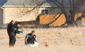 CHIEFTAIN PHOTO/MIKE SWEENEY — A Pueblo County Coroner's investigation team gathers evidence at the scene where a dead body was found Sunday in Pueblo West.