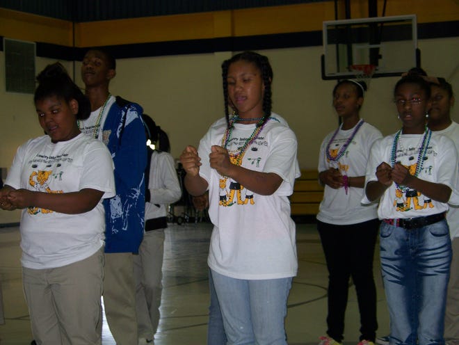 Students are pictured performing a song in sign language, courtesy of Jessie Joseph, Volunteer of the Year for Ascension Parish.