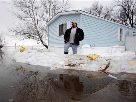 Virgil McKay stands on the sandbag dike that protects his home as the Red River continues to rise Monday, March 30, 2009, in Hendrum, Minn.