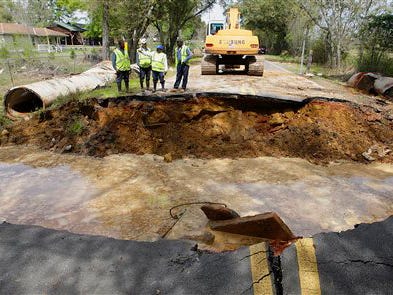 Mobile County Public Works department personnel examine the site of a road washout on Old Pascagoula Road near March Road, Tuesday, March 30, 2009 near Theodore, Ala. Heavy rains and water runoff washed out a section of the road over three culverts. More heavy rain was forecast Tuesday for the already soggy Southeast, worrying residents still recovering from a weekend soaking that flooded hundreds of homes, washed out roads and forced evacuations. (AP Photo/Press-Register, G.M. Andrews)