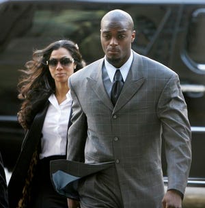 Plaxico Burress and his wife, Tiffany, enter the criminal courts building on Tuesday in New York. Burress’ case was adjourned until June, by which time a plea bargain might be struck.