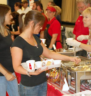 Kerri Landry of Gonzales samples food at the Gonzales Rotary Club’s annual Food Festival Tuesday night in the Gonzales Civic Center.