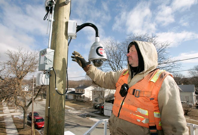 Brian Geiseman, an electrician for Wilson Electric, describes the components of a police video surveillance camera installed at the corner of Maple and North Horsman streets in Rockford. This camera is one of several recently placed throughout Rockford in high-crime areas.