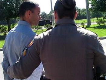Reinaldo Andujar Gonzalez is led to a patrol vehicle by Florida Highway Patrol Cpl. Susan Barge Tuesday morning.