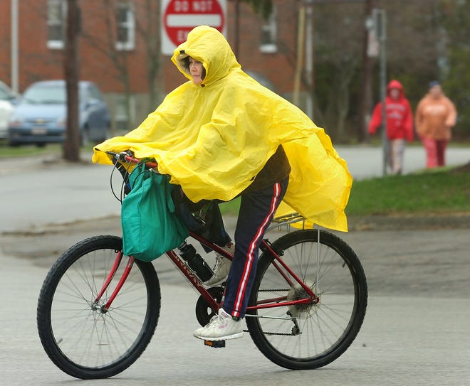 With a poncho providing some protection from Monday’s rain, a bicycle rider pedals along Copeland Street in Quincy.