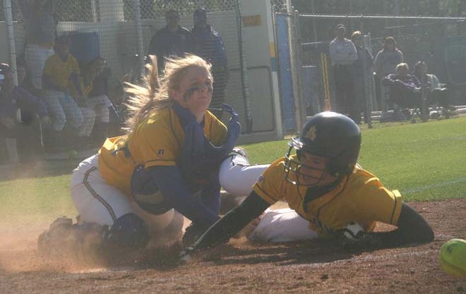 St. Amant’s Amanda Martin touches home plate after knocking the ball away from East Ascension’s Tiffany Robinson in the second inning of the Lady Gators’ 2-1 District 6-5A victory Tuesday afternoon.