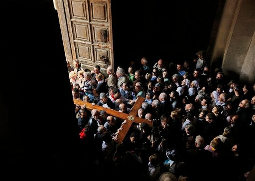 Christian worshippers carry the cross of the Latin Patriarchate into the Church of the Holy Sepulcher, traditionally believed by many to be the site of the crucifixion of Jesus Christ, during the Good Friday procession in Jerusalem's Old City, Friday, April 10, 2009. Hundreds of Christian clergymen, worshippers and pilgrims marked Good Friday at Jerusalem's Church of the Holy Sepulcher, where Christian tradition says Jesus was crucified and resurrected. (AP Photo/Kevin Frayer)