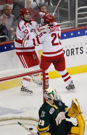 Boston University's Colin Wilson (33) celebrates his winning goal with teammate Jason Lawrence (21) against Vermont goaltender Rob Madore (29) during the third period of a semifinal of the NCAA men's college hockey tournament Frozen Four Thursday in Washington.