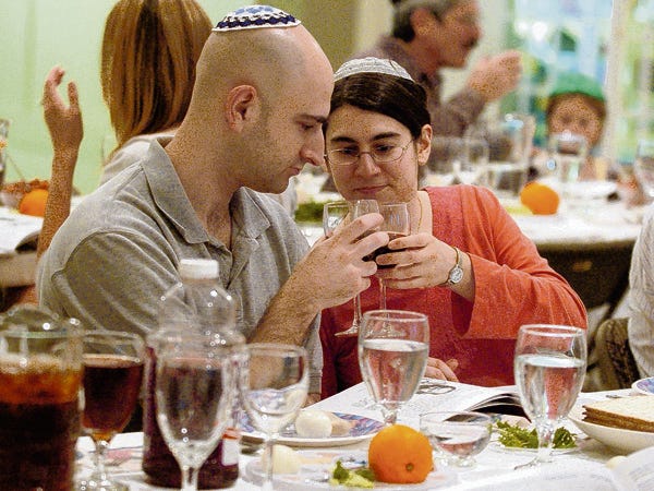 Todd Goldfinger and Rebecca Kemp toast each other while observing the Passover Seder at B'nai Israel Synagogue Thursday.