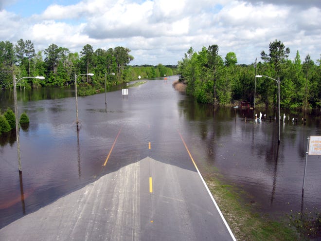 The Suwannee River floods the CR 249 bridge in Suwannee County on Friday morning.