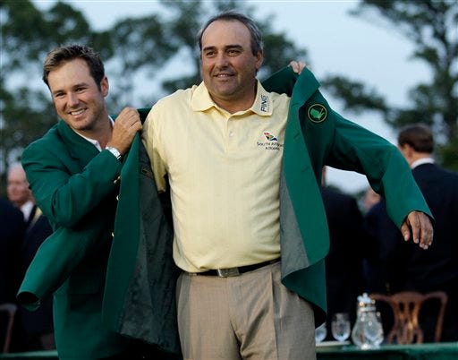 Former Masters' champion Trevor Immelman of South Africa helps 2009 Masters golf champion Angel Cabrera of Argentina with his Masters' green jacket at the Augusta National Golf Club in Augusta, Ga., Sunday, April 12, 2009. (AP Photo/David J. Phillip)