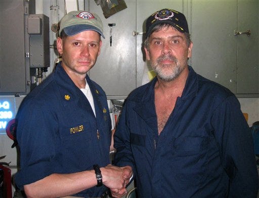 In this photo released by the U.S. Navy, Maersk-Alabama Capt. Richard Phillips, right, shakes hands with Lt. Cmdr. David Fowler, executive officer of USS Bainbridge after being rescued by U.S Naval Forces off the coast of Somalia on Sunday April 12, 2009. (AP Photo/ U.S. Navy)