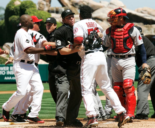 The Angels' Bobby Abreu is held back by home plate umpire Paul Schreiber after Red Sox starter pitcher Josh Beckett threw a high pitch during the first inning of Sunday's game.