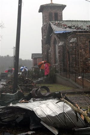Members of St. Agnes Church leave their tornado damaged church after Easter service, Sunday, April 12, 2009 in Mena Ark.