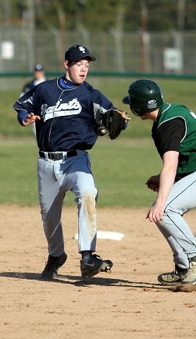 EJ Hersom/Staff photographer 
St. Thomas shortstop Ben Johnson, left, prepares to tag out Dover's Matt Kimball during action Monday in Dover.