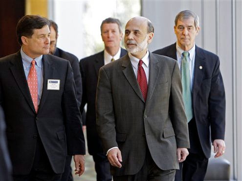 Federal Reserve Chairman Ben Bernanke, center, leaves after speaking at a symposium in Charlotte, N.C., Friday, April 3, 2009. While acknowledging that the Federal Reserve was "extremely uncomfortable" about last year's bailouts of big financial companies, Fed Chairman Ben Bernanke said Friday the central bank's strategy to ease the financial crisis is working.