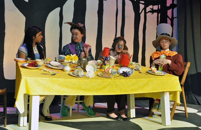 Alice (Ashley Estrada) has tea with, from left, March Hare (Alex Sharp), Dormous (Kate Cowger) and the Mad Hatter (Ethan Carlson) in a scene from Cair Paravel Latin School’s stage adaptation of Lewis Carroll’s “Alice’s Adventures in Wonderland.”