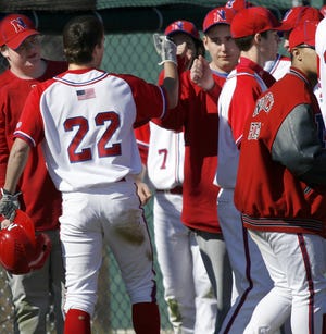 Natick's Brett Flutie is congratulated after scoring a run during the Red and Blue's 7-6 win over rival Framingham.