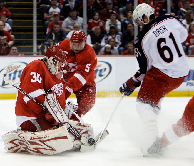Detroit Red Wings goalie Chris Osgood (30) stops Columbus Blue Jackets' Rick Nash's shot as Red Wings defenseman Nicklas Lidstrom looks on in the first period of a first-round NHL hockey playoff game in Detroit, Thursday, April 16, 2009.  (AP Photo/Paul Sancya)