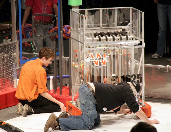 From left, Winnebago High School's Winnovation robotics team captain and driver Dillon Carey and mentor Scott Hill prepare their robot "Snuggles" at the FIRST Wisconsin regional at U.S. Cellular Arena in Milwaukee in March.