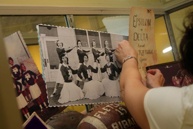 MAGGIE FITZROY/StaffTaryn Rodriguez-Boette hangs photos and memorabilia for a display on Fletcher High School's history.