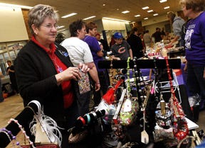 Karen Strohecker of Pearl City checks out the merchandise at Connie and Friends team table during the Relay for Life Expo at Lincoln Mall.
