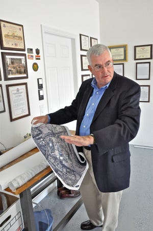 Lt. Col. Leo McCloskey talks Thursday about flight maneuvers while holding one of the maps he brought back from Iraq.