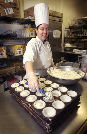 Enmie Fox, a graduate of the StarFish Caf?, prepares chocolate chip muffins for the customers of Caf? SCAD. (Steve Bisson/Savannah Morning News)