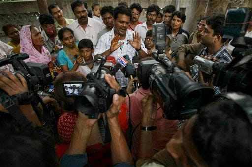 Rafiq Qureshi, center, father of Slumdog Millionaire actor Rubina Ali gestures as he speaks to journalists Sunday at a police station in Mumbai, India, Sunday, April 19, 2009. Qureshi was questioned by the police again on Monday regarding allegations that he tried to sell his daughter Rubina.