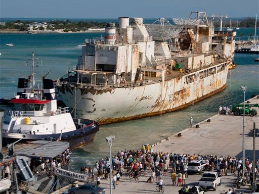 In this photo released Wednesday, April 22, 2009 by the Florida Keys News Bureau, Key West, Fla., residents watch as the the retired U.S. missile tracking ship Gen. Hoyt S. Vandenberg arrives in Key West after the ship was towed from Norfolk, Va. The 523-foot-long ship is to be intentionally sunk off Key West in late May to become an artificial reef in the Florida Keys National Marine Sanctuary.