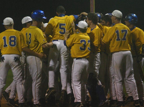 East Ascension’s Bradly Day is mobbed by teammates after hitting a grand slam in the fourth inning of the Spartans’ 15-0 victory over St. Amant Tuesday night.