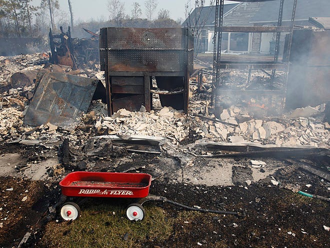 A house lies in ruins on Thursday afternoon in the Barefoot Resort community in North Myrtle Beach. South Carolina's biggest wildfire in more than three decades a blaze four miles wide destroyed dozens of homes Thursday and threatened some of the area's world-famous golf courses at the height of the spring tourist season.