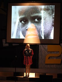 Elise Brubaker stands in front of a visual to highlight the plight of world hunger during Showtime 29 at the Jeannette Lloyd Theatre in Freeport.