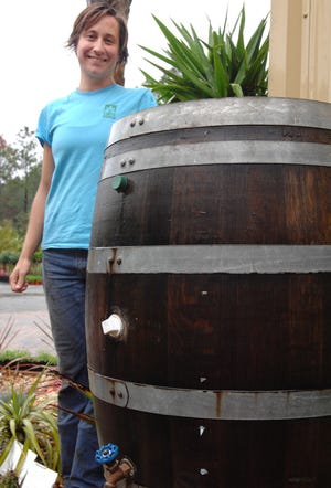 RICK WILSON/The Times-UnionDevon Ritch of Jacksonville's Earth Works shows one of the landscape and garden center's rain barrels made from recycled oak wine casks.