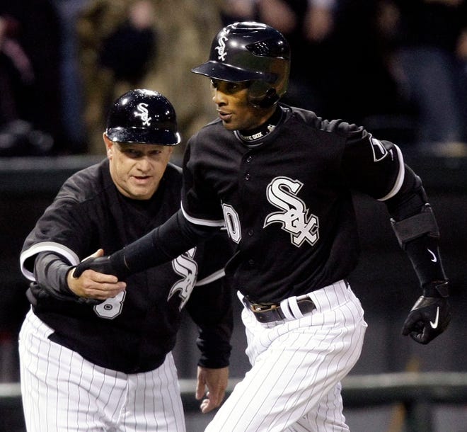 Chicago White Sox third base coach Jeff Cox sends Alexei Ramirez home after he hit a grand slam during the fifth inning against the Toronto Blue Jays in Chicago, Saturday, April 25, 2009.