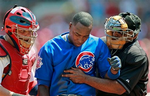 Chicago Cubs' Alfonso Soriano, center, is aided by home plate umpire Laz Diaz and St. Louis Cardinals' Yadier Molina after being hit in the head by a pitch in the second inning of a baseball game, Sunday, April 26, 2009, in St. Louis. Soriano remained in the game. (AP Photo/Tom Gannam)