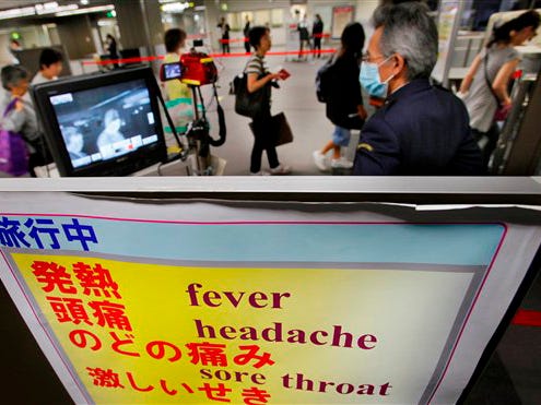 A quarantine officer monitors travelers with a thermographic device at an arrival gate at Narita International Airport in Narita, east of Tokyo, Japan, Sunday, April 26, 2009. The World Health Organization warned countries around the world April. 25 to be on alert for any unusual flu outbreaks after a unique new swine flu virus was implicated in possibly dozens of human deaths in North America. WHO Director-General Margaret Chan said the outbreak in Mexico and the United States constituted a "public health emergency of international concern."
