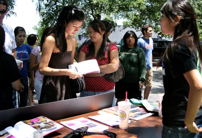 University of Florida juniors Anna Yeung, left, and Pang Khang sign up for volunteer hours with Global Empowerment, a UF student organization.
University of Florida juniors Anna Yeung, left, and Pang Khang sign up for volunteer hours with Global Empowerment, a UF student organization.