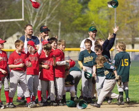 Team members of the Angels and the Athletics toss their baseball caps into the air in celebration of Kittery Little League Opening Day at Tobey Field in Kittery, Maine, on Saturday.
